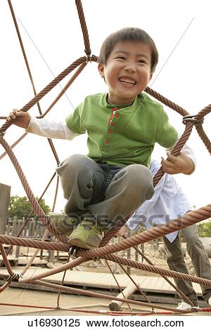 A small boy enjoying himself sitting in structure of ropes View Large Photo Image Stock Photography - A small boy enjoying himself sitting in structure of ropes. Fotosearch