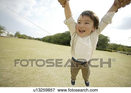 A small boy is being lifted in mid air View Large Photo Image Stock Photo - A small boy is being lifted in mid air. Fotosearch
