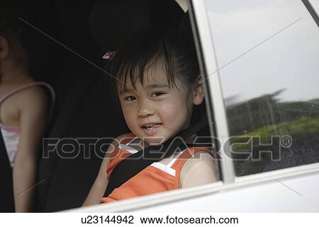 Stock Image - Girls in the rear seats of a car. Fotosearch