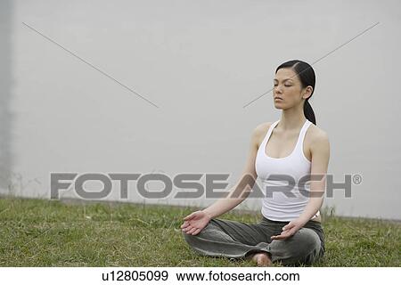 Stock Photo - Front view of a woman in lotus position. Fotosearch