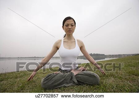 Front view of a woman in lotus position View Large Photo Image Stock Photo - Front view of a woman in lotus position. Fotosearch