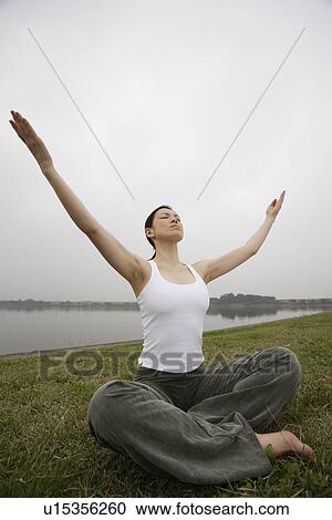 Front view of a young woman in lotus position View Large Photo Image Stock Image - Front view of a young woman in lotus position. Fotosearch