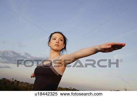 Stock Photography - Low angle view of a young woman exercising. Fotosearch