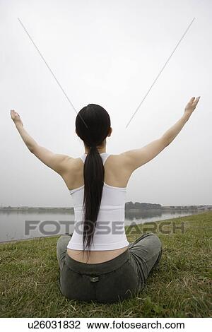 Rear view of a young woman in lotus position View Large Photo Image Stock Image - Rear view of a young woman in lotus position. Fotosearch