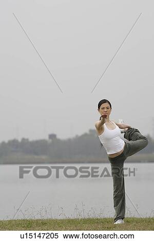 View of a young woman balancing on one leg View Large Photo Image Stock Photography - View of a young woman balancing on one leg. Fotosearch