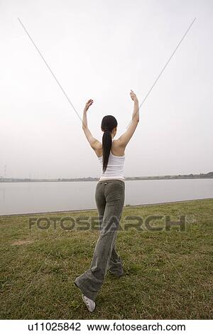 Stock Image - View of a young woman exercising outdoors. Fotosearch