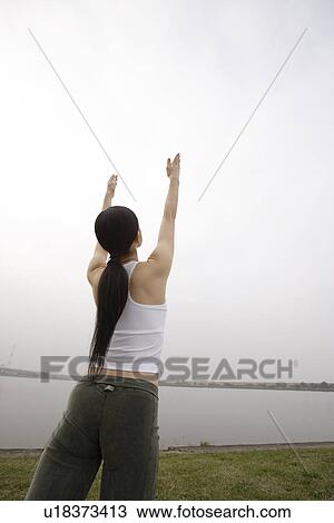 Stock Image - View of a young woman exercising outdoors. Fotosearch