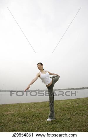 Stock Image - View of a young woman exercising outdoors. Fotosearch