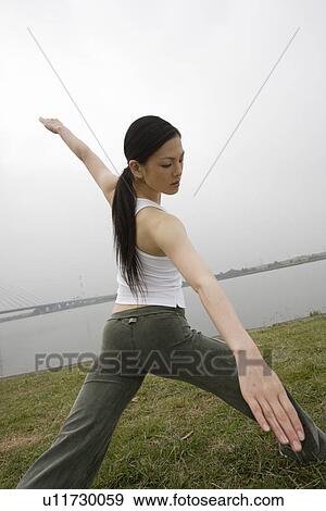 Stock Photo - View of a young woman exercising outdoors. Fotosearch