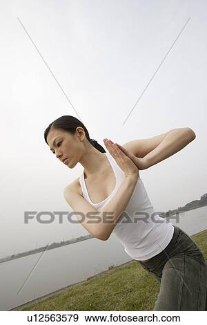 Stock Photo - View of a young woman exercising outdoors. Fotosearch