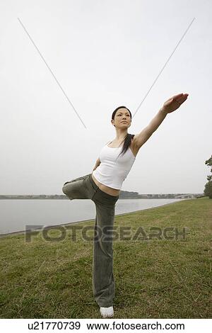 Stock Photo - View of a young woman exercising outdoors. Fotosearch