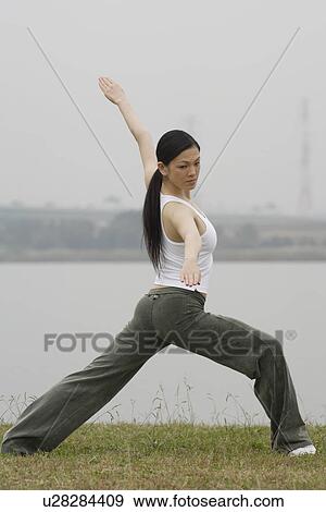 Stock Photo - View of a young woman exercising outdoors. Fotosearch