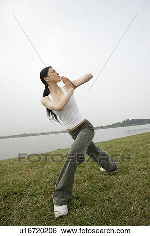 Stock Photograph - View of a young woman exercising outdoors. Fotosearch