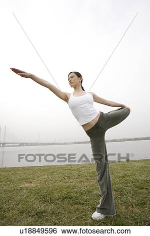 Stock Photograph - View of a young woman exercising outdoors. Fotosearch