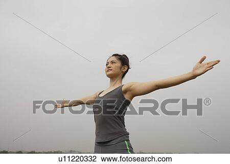 Stock Image - View of a young woman performing yoga. Fotosearch