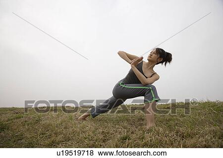 Stock Photo - View of a young woman performing yoga. Fotosearch
