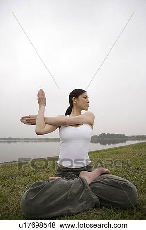 View of a young woman practicing yoga View Large Photo Image Stock Photo - View of a young woman practicing yoga. Fotosearch