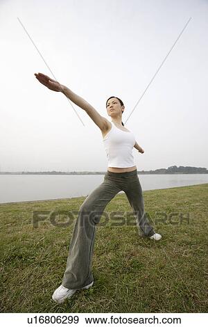 View of a young woman stretching her body View Large Photo Image Stock Photo - View of a young woman stretching her body. Fotosearch