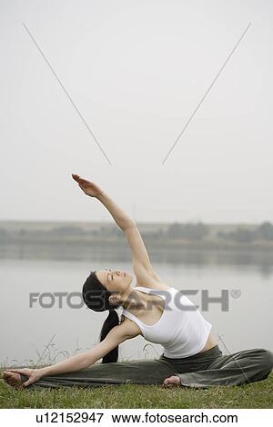 Stock Photo - View of a young woman stretching out on the ground. Fotosearch