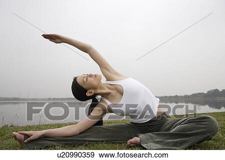 Stock Photo - View of a young woman stretching out on the ground. Fotosearch