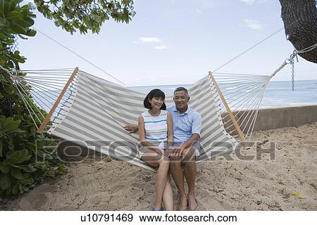 A couple sitting on hammock View Large Photo Image Stock Photo - A couple sitting on hammock. Fotosearch