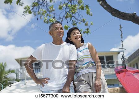A couple standing together looking away View Large Photo Image Stock Image - A couple standing together looking away. Fotosearch