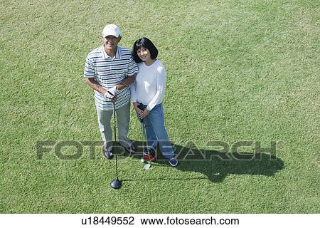 Stock Image - Elevated view of a couple with golf club. Fotosearch