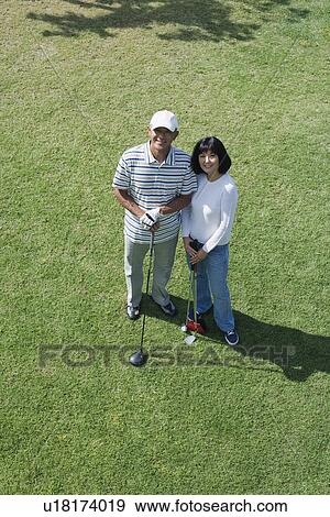 Stock Photo - Elevated view of a couple with golf club. Fotosearch