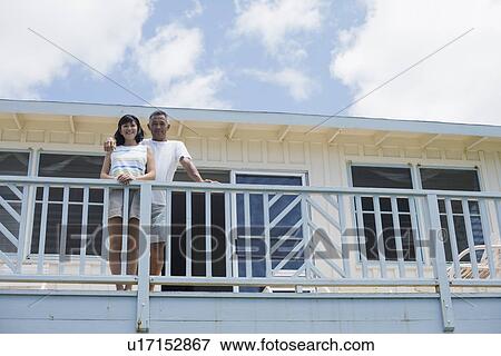 Stock Photo - Low angle view of a couple on balcony. Fotosearch