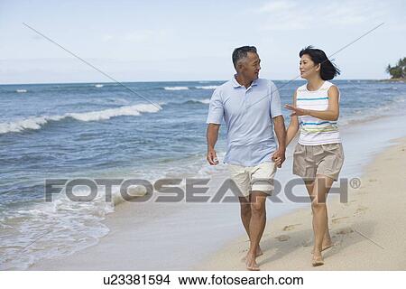 Picture - View of a couple walking at beach. Fotosearch