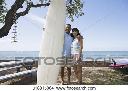 Picture - View of a couple with surfboard smiling. Fotosearch