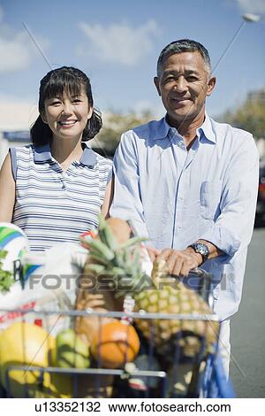 View of a couple with trolley View Large Photo Image Stock Image - View of a couple with trolley. Fotosearch