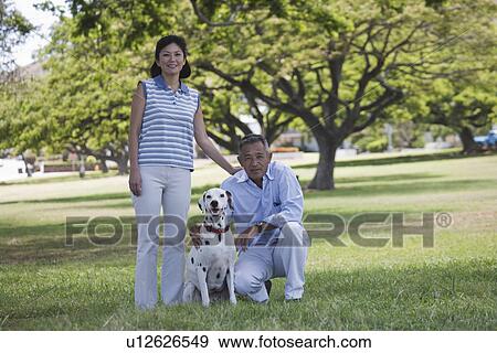 A couple with dog in park View Large Photo Image Stock Photo - A couple with dog in park. Fotosearch