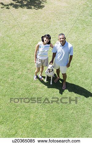 Elevated view of a couple standing with dog View Large Photo Image Stock Photography - Elevated view of a couple standing with dog. Fotosearch