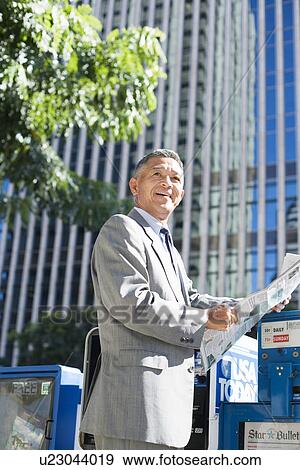 Stock Photo - Businessman holding newspaper. Fotosearch
