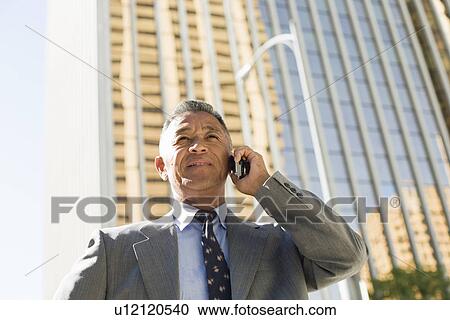 Stock Image - Businessman using mobile phone. Fotosearch