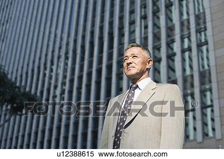 Stock Photography - Low angle view of a businessman looking away. Fotosearch