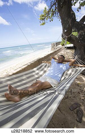 Stock Image - Mature man lying on hammock. Fotosearch