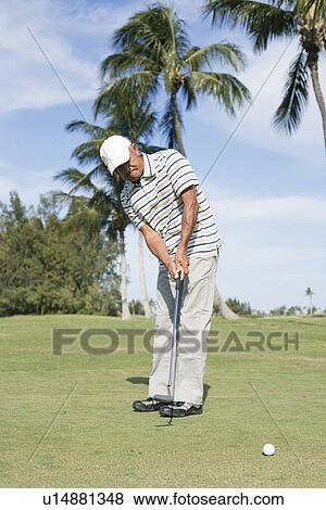 Stock Photo - Mature man playing golf. Fotosearch