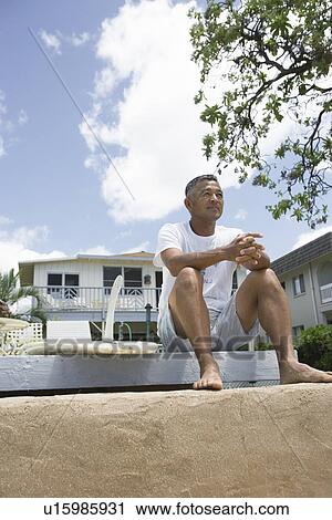 Stock Image - Mature man sitting looking away. Fotosearch
