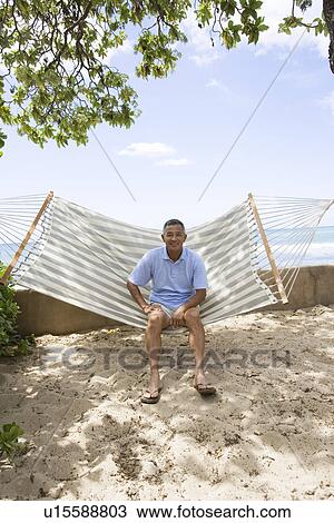 Mature man sitting on hammock View Large Photo Image Stock Image - Mature man sitting on hammock. Fotosearch