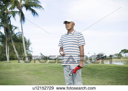 Mature man standing on golf course View Large Photo Image Stock Photo - Mature man standing on golf course. Fotosearch