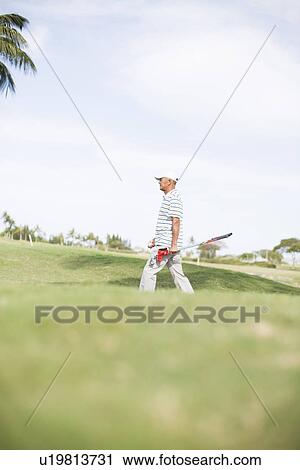 Mature man walking on golf course View Large Photo Image Stock Image - Mature man walking on golf course. Fotosearch