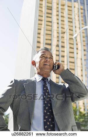 Stock Image - View of a businessman using mobile phone. Fotosearch