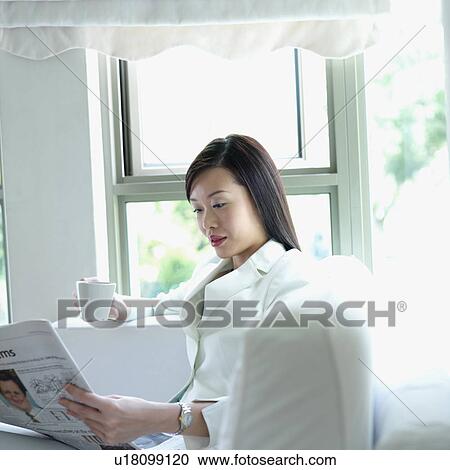 Businesswoman reading a newspaper View Large Photo Image Stock Image - Businesswoman reading a newspaper. Fotosearch