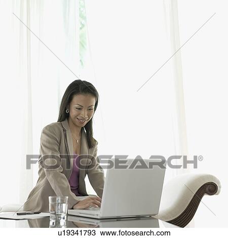 Businesswoman working on a laptop View Large Photo Image Stock Image - Businesswoman working on a laptop. Fotosearch