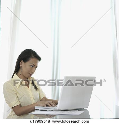 Stock Photo - Businesswoman working on a laptop. Fotosearch