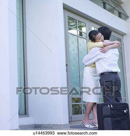 Low angle view of a young woman and a mid adult man embracing View Large Photo Image Stock Image - Low angle view of a young woman and a mid adult man embracing. Fotosearch