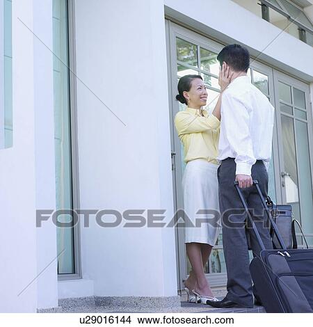 Low angle view of a young woman standing face to face with a mid adult man View Large Photo Image Picture - Low angle view of a young woman standing face to face with a mid adult man. Fotosearch