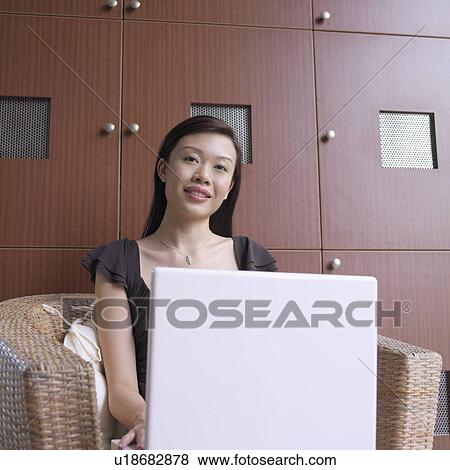 Stock Photo - Portrait of a businesswoman sitting in front of a laptop. Fotosearch